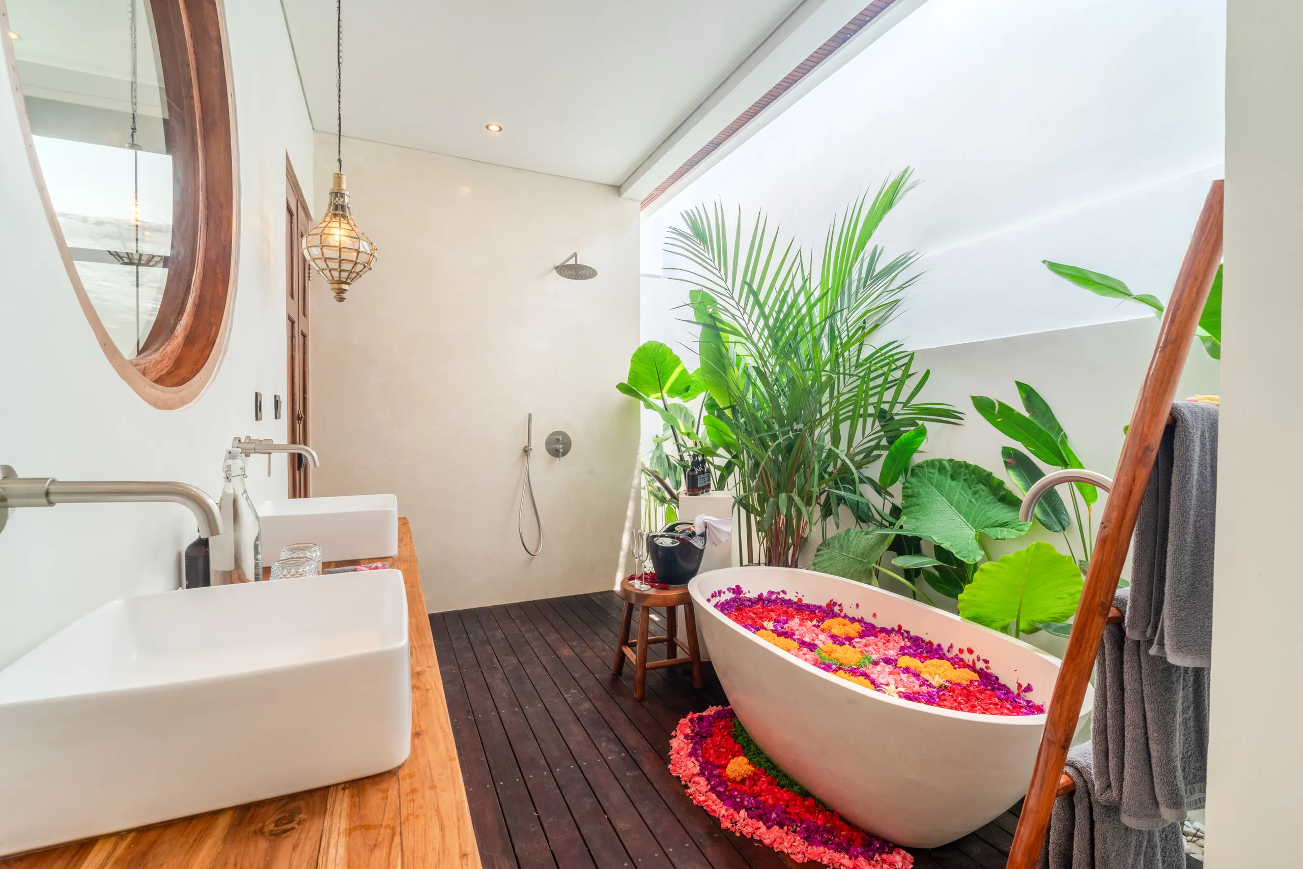 Semi-outdoor bathroom with freestanding bathtub, rainfall shower and tropical plants at Villa Sofra
