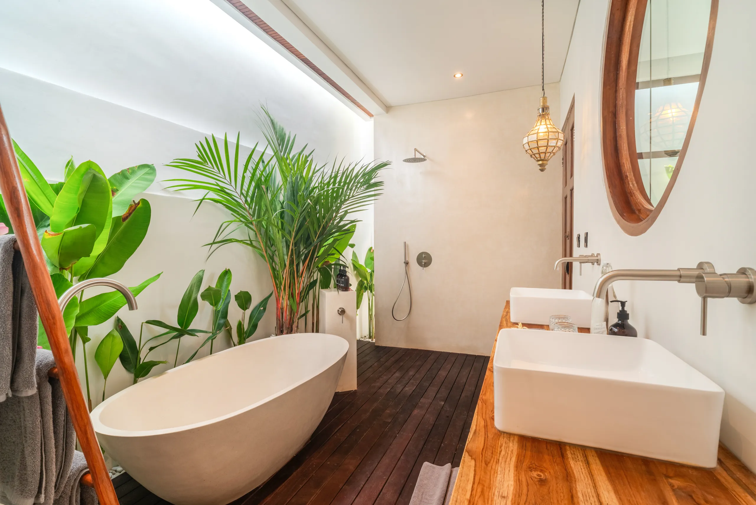 Semi-outdoor bathroom with freestanding bathtub, rainfall shower and indoor plants at Villa Sofra