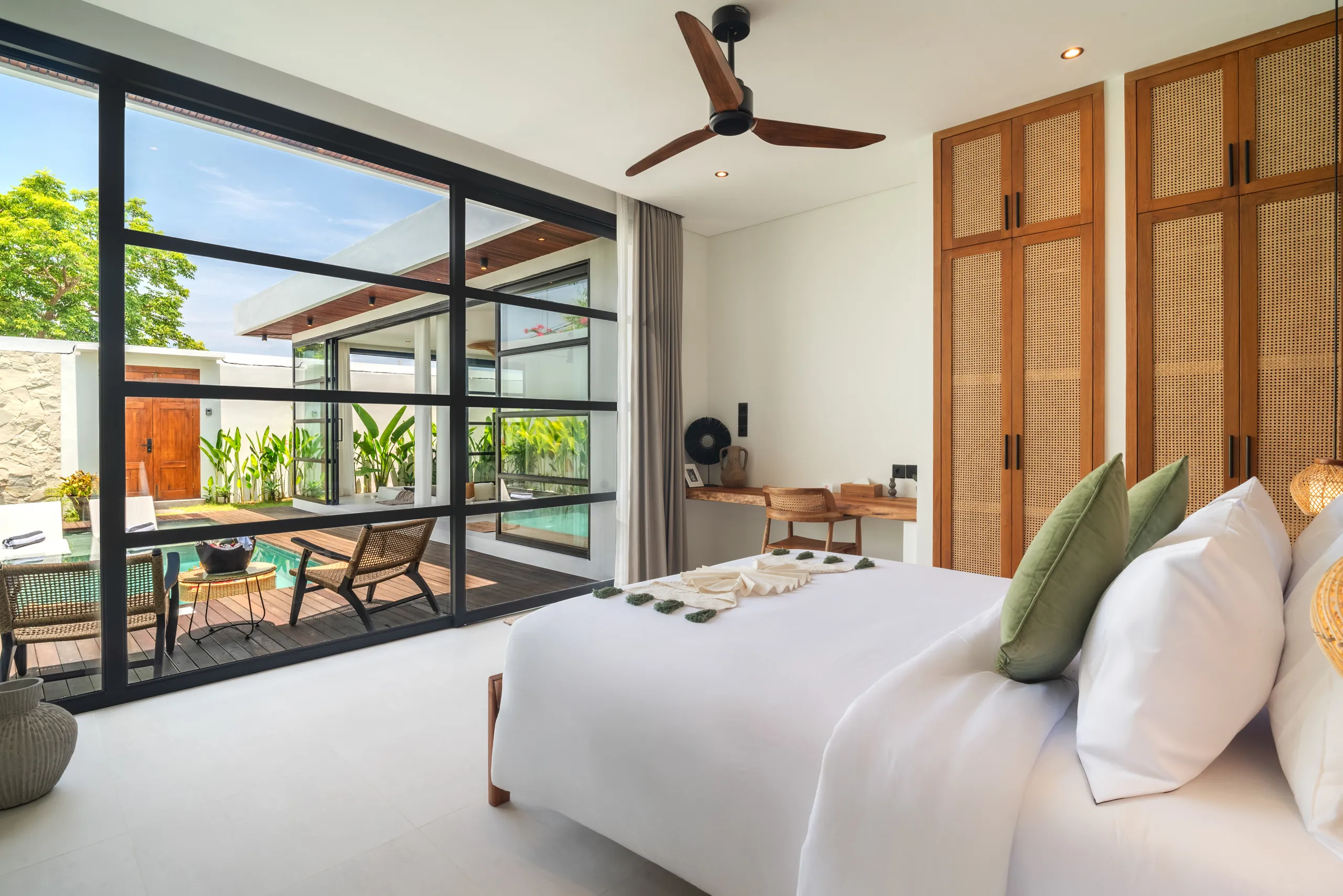 Bedroom with floor-to-ceiling windows overlooking the private pool deck at Villa Sofra