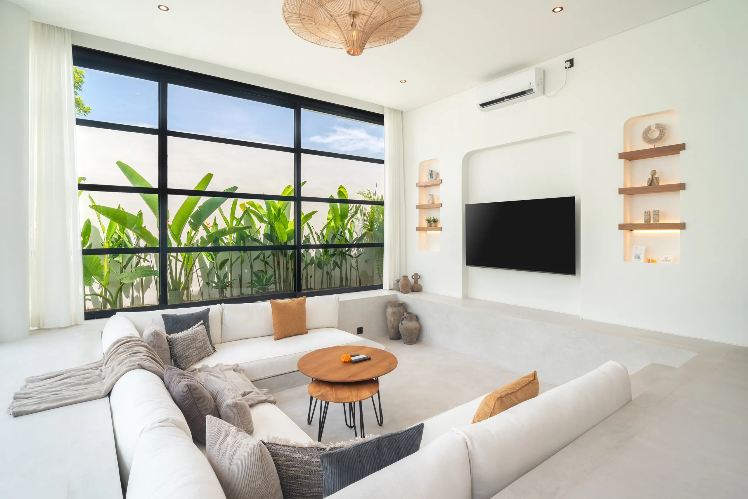 Sunken living room with white sofa and banana tree garden view at Villa Sofra