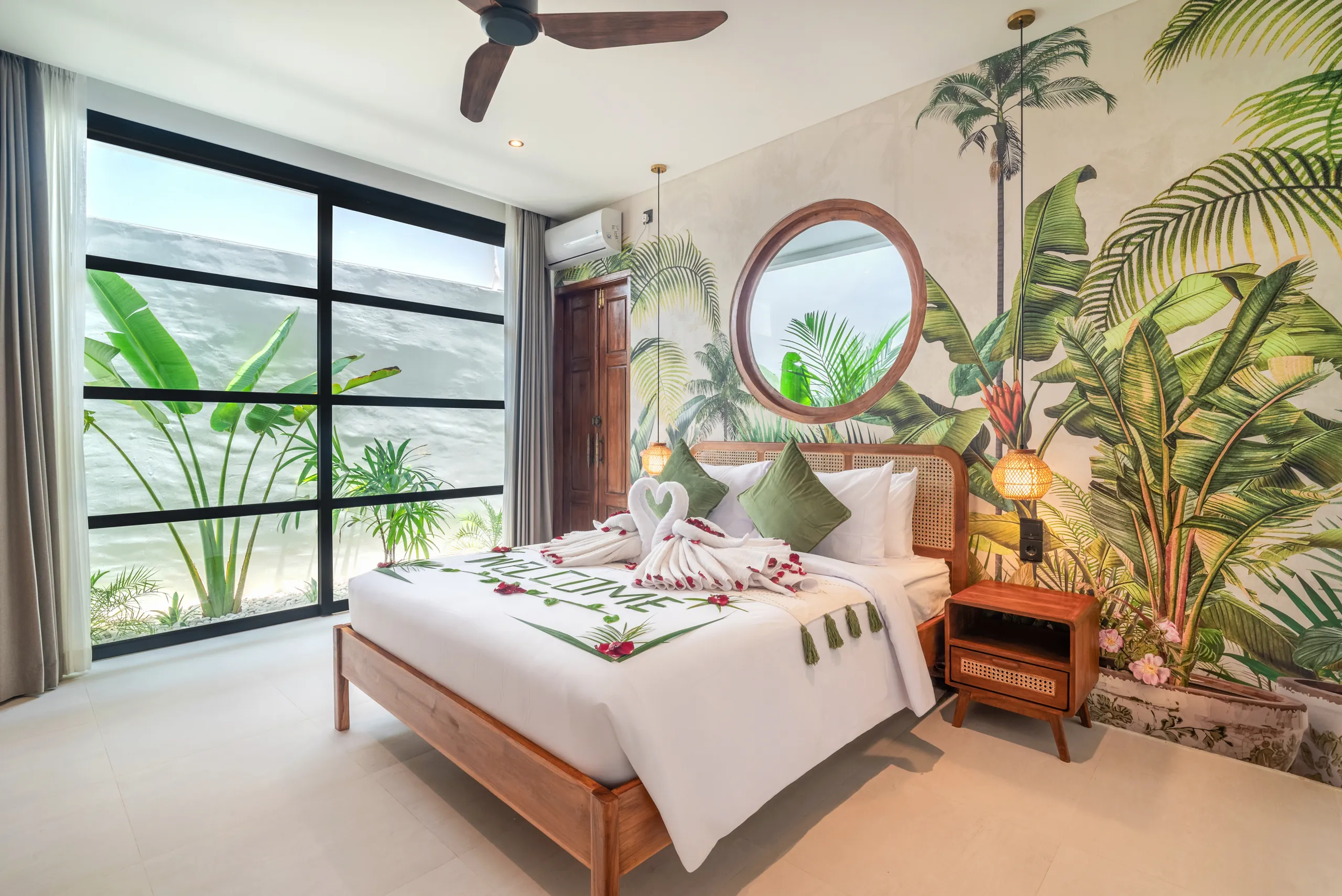 Master bedroom with tropical mural wallpaper and welcome towel art at Villa Sofra Bingin