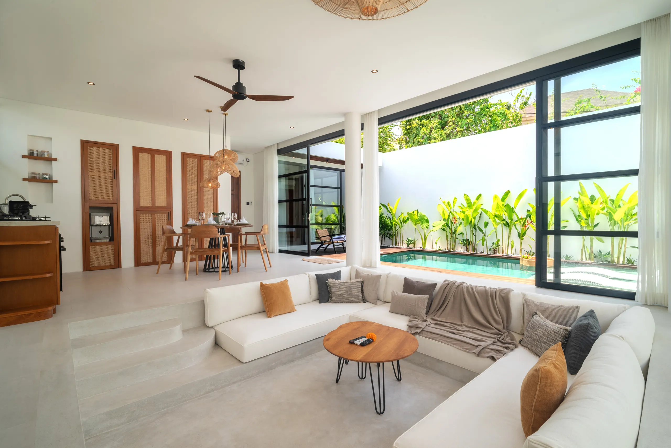 Sunken living room corner with white sofa, coffee table and garden views at Villa Sofra