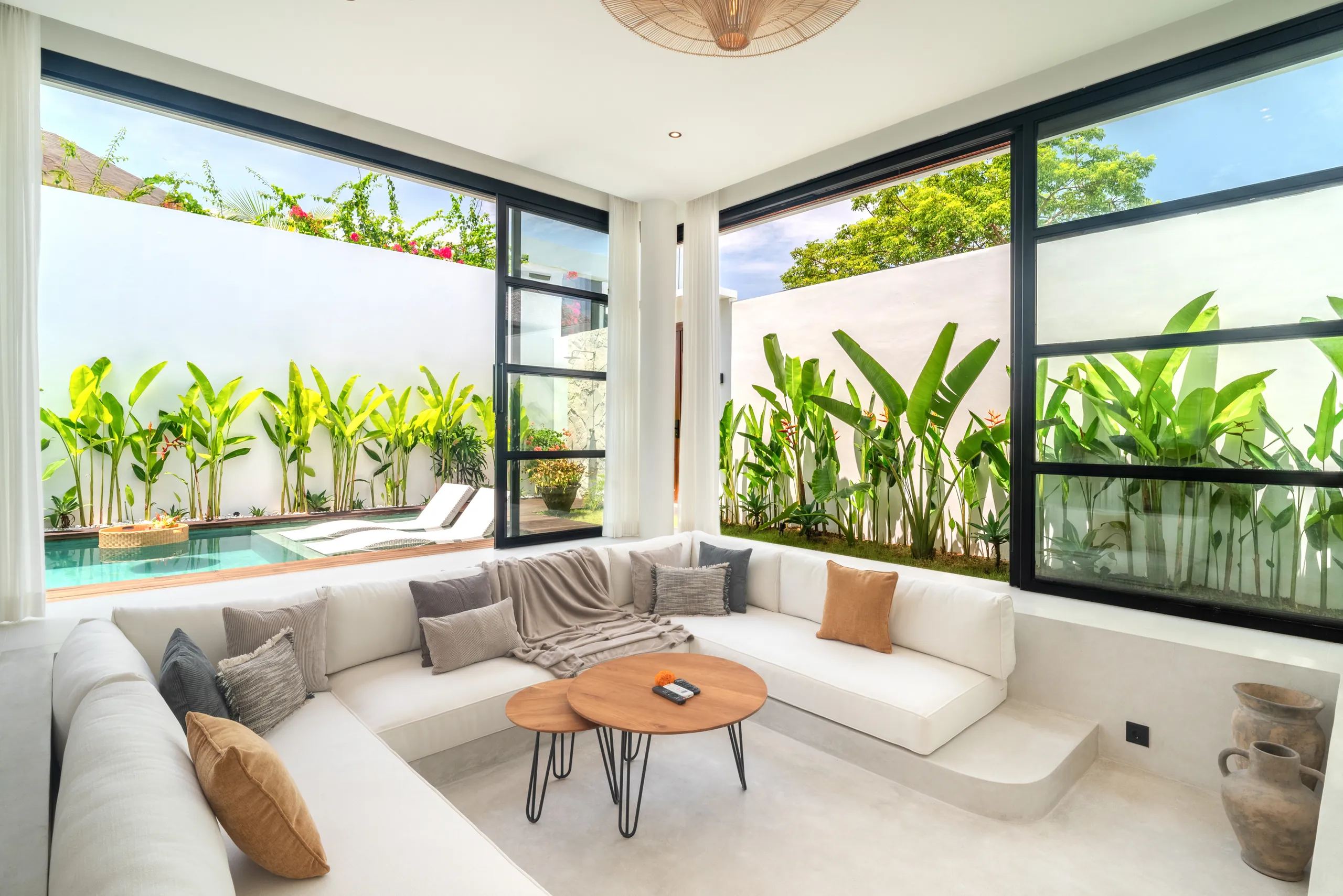 Dining area with teak table, rattan pendant lights and pool view at Villa Sofra