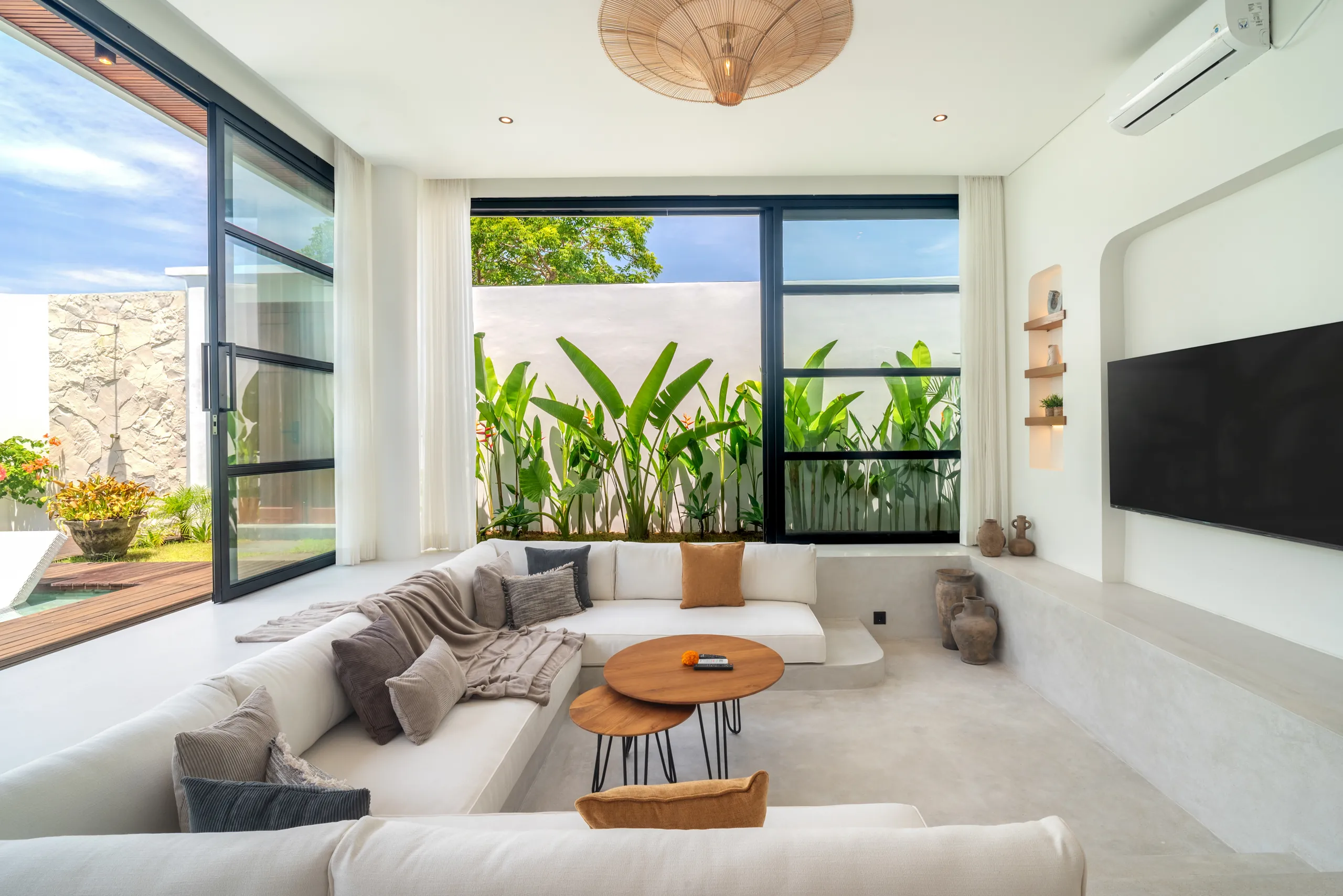 Dining area and living room at night lit by rattan pendant lights at Villa Sofra