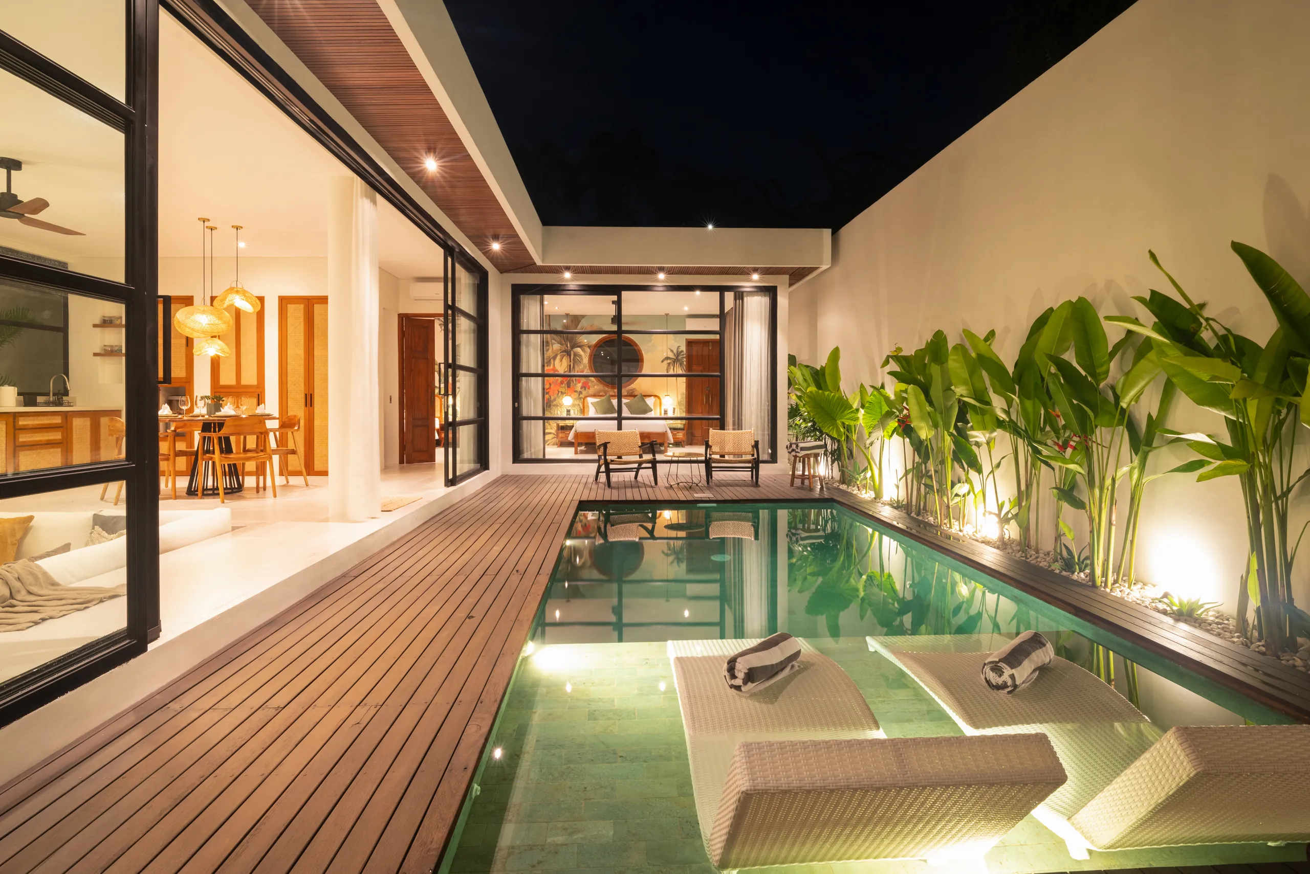 Night view of private pool with garden lighting and lounge chairs at Villa Sofra