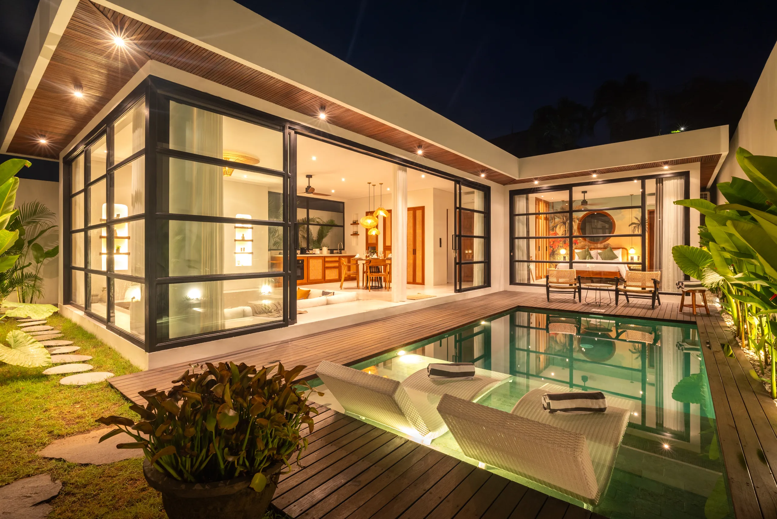 Villa exterior at night with pool, teak deck and garden fully illuminated at Villa Sofra